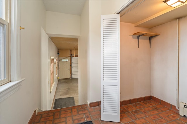 hall with a baseboard heating unit and baseboards