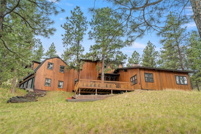 rear view of property with a lawn and a deck