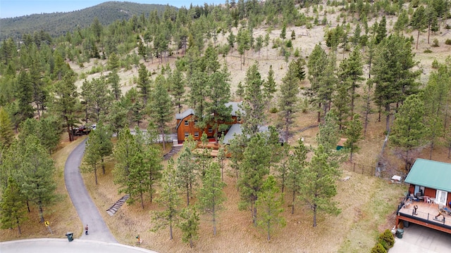 view of subject property featuring a mountainous background and a heavily wooded area