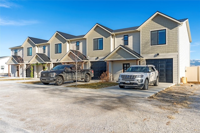 townhome / multi-family property with a garage, a residential view, and driveway