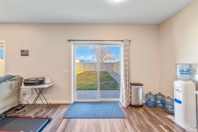 doorway with wood finished floors and baseboards