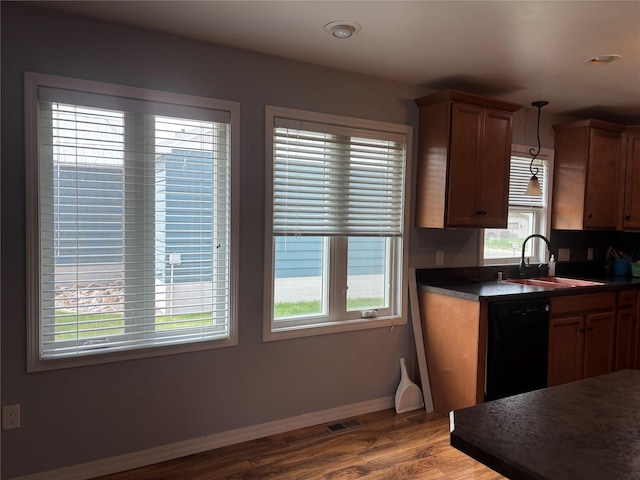 307 S Iowa St, Conrad, MT 59425 - kitchen with a sink, black dishwasher, dark countertops, wood finished floors, and baseboards