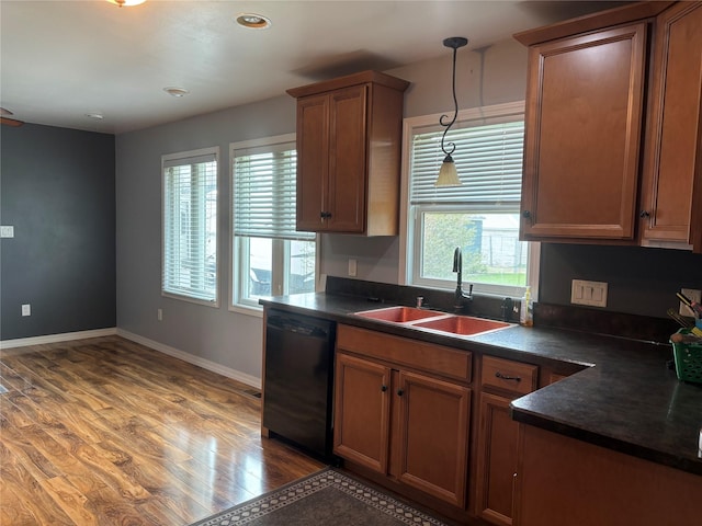 307 S Iowa St, Conrad, MT 59425 - kitchen with black dishwasher, a sink, dark countertops, and light wood-style floors