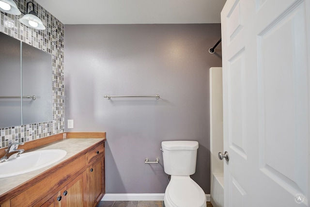 bathroom with vanity, toilet, tasteful backsplash, a shower, and baseboards
