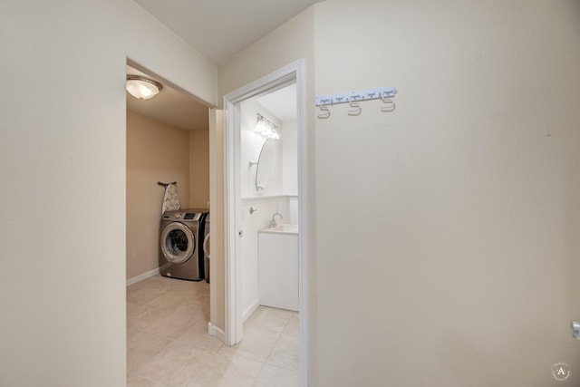 laundry room with light tile patterned floors, independent washer and dryer, and baseboards