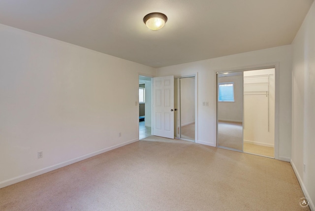 unfurnished bedroom with light carpet and baseboards