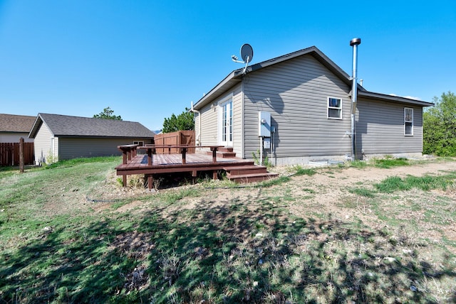 back of property featuring a deck and a lawn