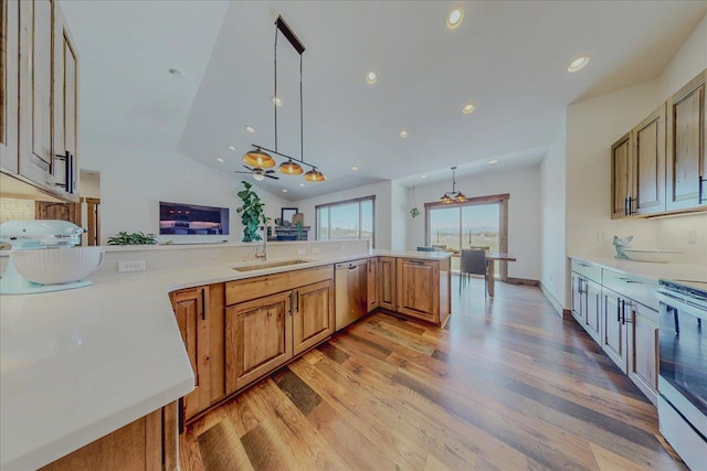 kitchen featuring a sink, appliances with stainless steel finishes, light wood finished floors, light countertops, and recessed lighting