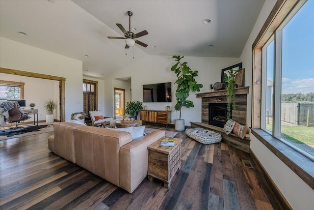 living room with lofted ceiling, wood finished floors, a ceiling fan, and a stone fireplace