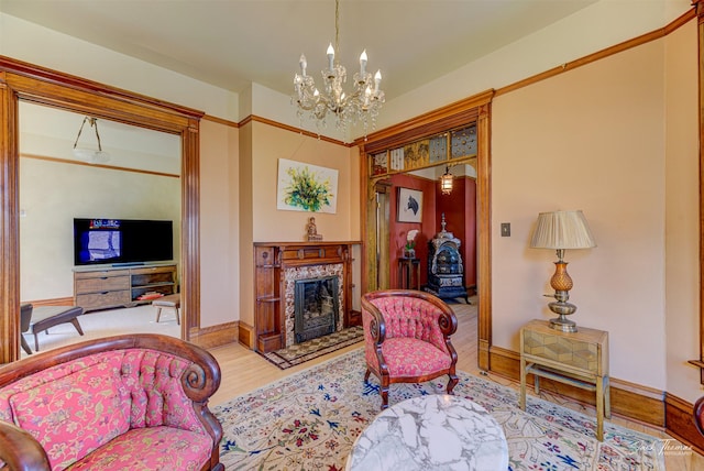living room with wood finished floors, a chandelier, baseboards, and a premium fireplace