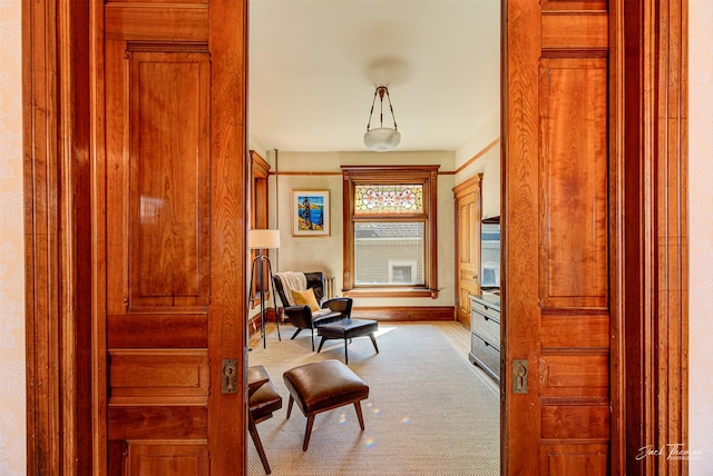 living area featuring baseboards and carpet flooring