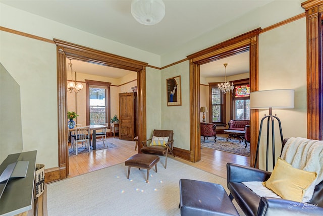 living area featuring a chandelier, wood finished floors, plenty of natural light, and baseboards