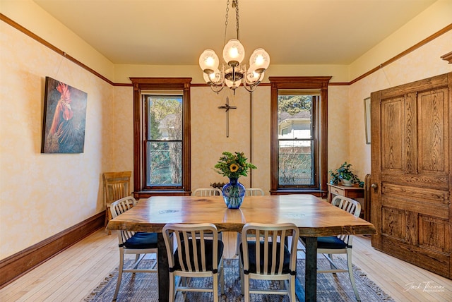 dining area with light wood-type flooring, plenty of natural light, a chandelier, and baseboards