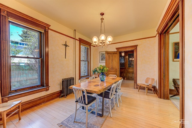 dining space with radiator, a chandelier, and light wood-style floors
