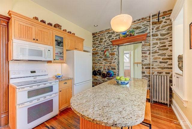 kitchen featuring white appliances, radiator heating unit, wood-type flooring, a center island, and glass insert cabinets
