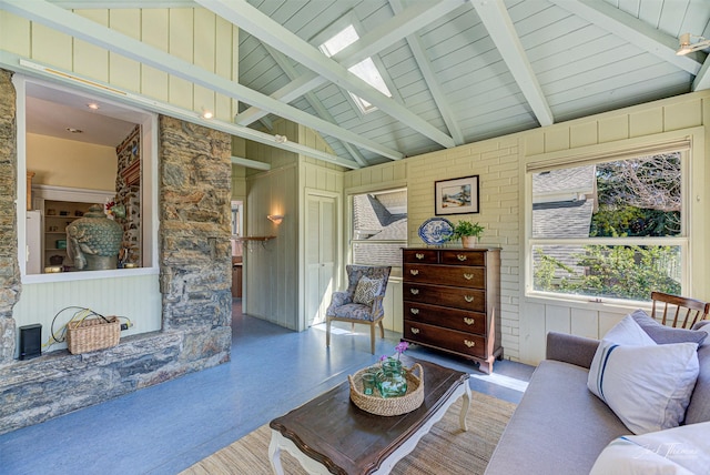 living room with beamed ceiling, a skylight, high vaulted ceiling, and wood ceiling