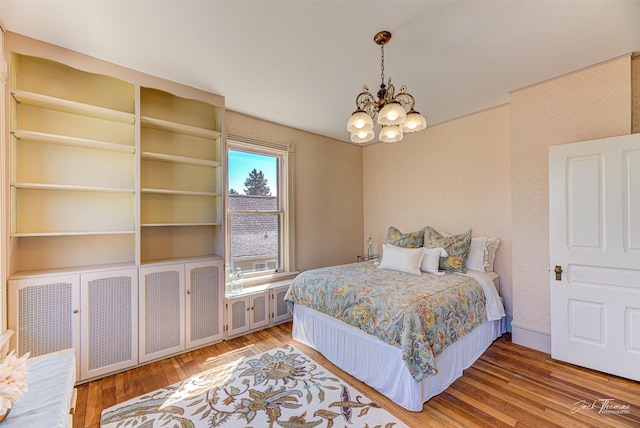 bedroom featuring a chandelier and wood finished floors