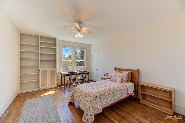 bedroom featuring hardwood / wood-style flooring, a ceiling fan, and baseboards
