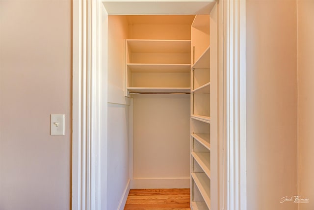 walk in closet with wood finished floors