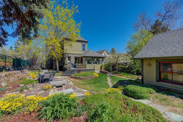 back of property with a patio, roof with shingles, and a wooden deck