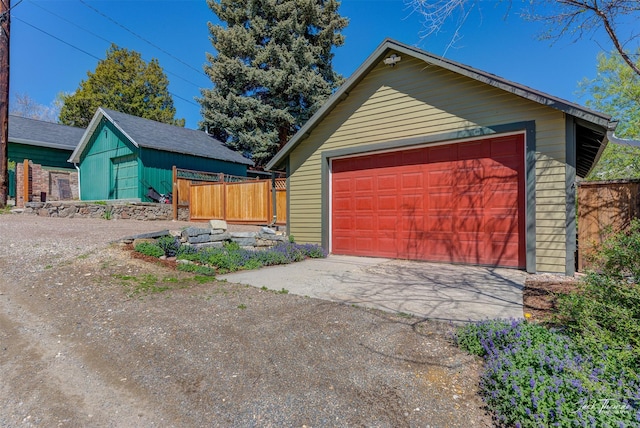 detached garage featuring fence