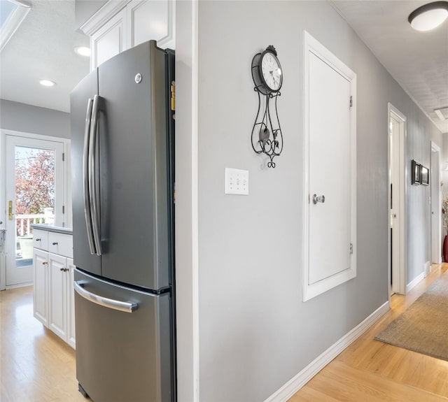 kitchen featuring freestanding refrigerator, light wood-type flooring, white cabinets, baseboards, and recessed lighting