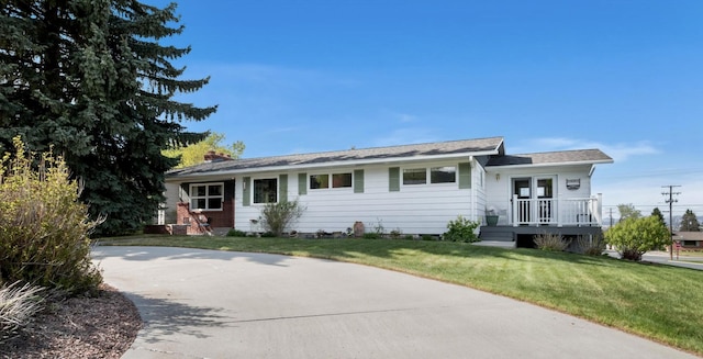 ranch-style house featuring a front yard and a chimney