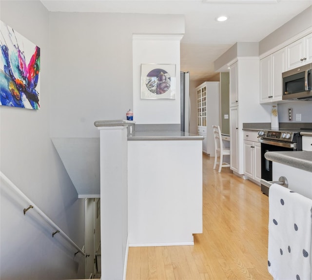 kitchen with stainless steel appliances, white cabinets, light wood-type flooring, and recessed lighting