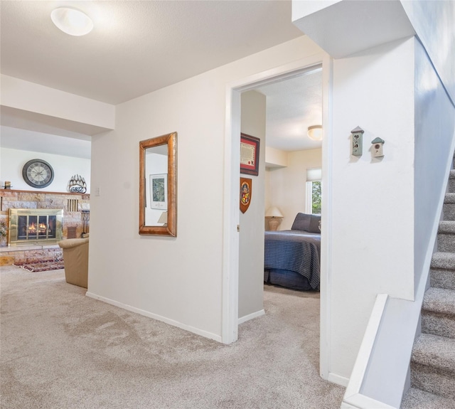 hall featuring carpet flooring, stairs, and baseboards