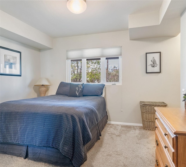 bedroom featuring light colored carpet and baseboards