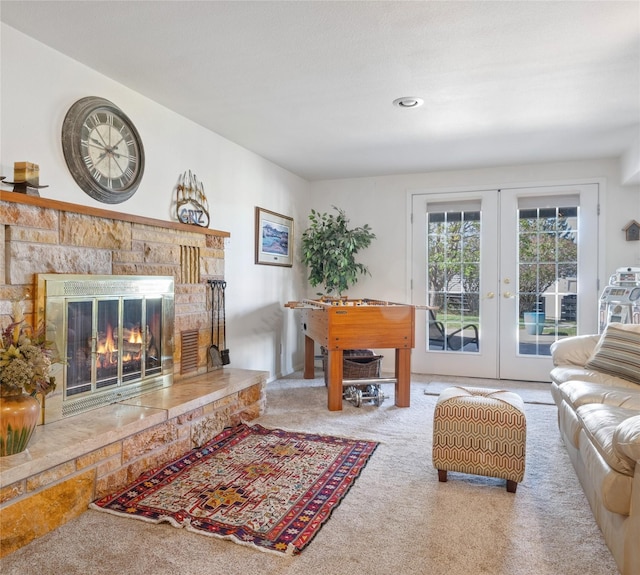 living area featuring carpet floors, french doors, and a glass covered fireplace