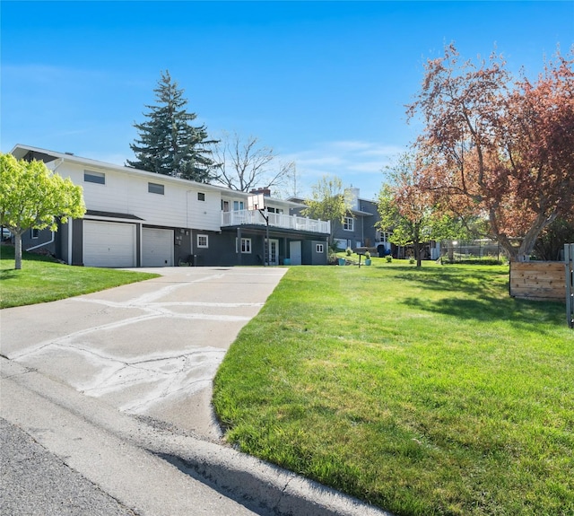 view of front of home with an attached garage, a front lawn, and concrete driveway