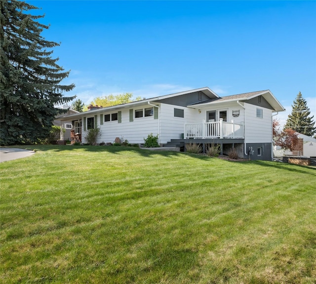view of front of house with a front yard and a wooden deck