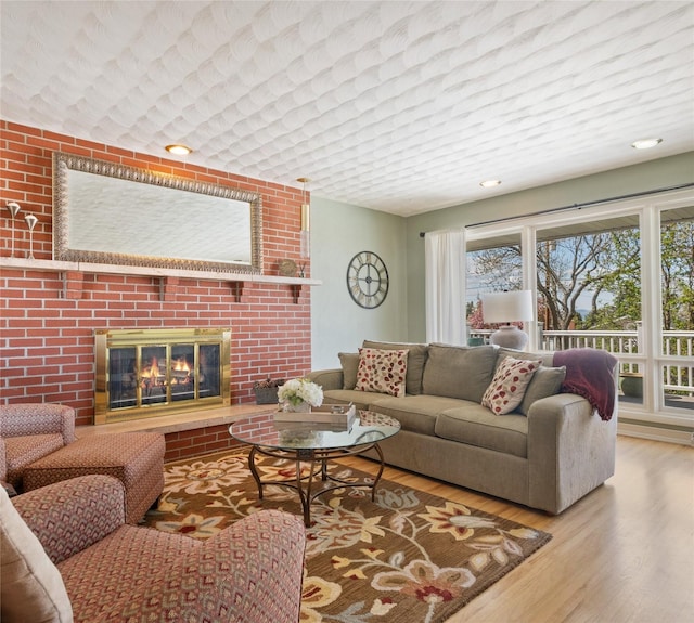 living area with wood finished floors and a brick fireplace
