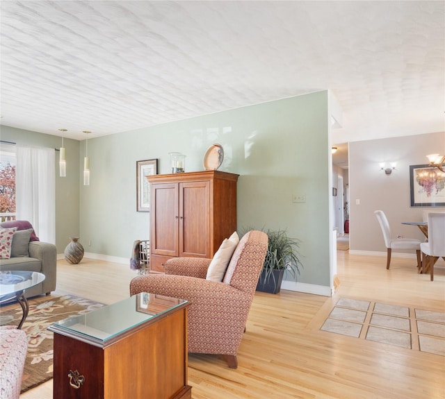 living area featuring light wood-style flooring and baseboards