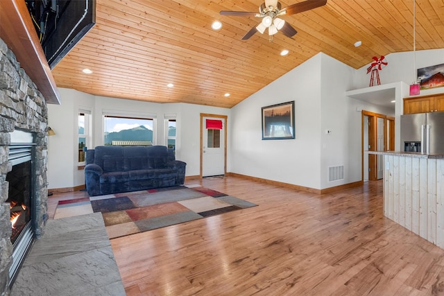 999 Websters Way, Stevensville, MT 59870 - living room with a stone fireplace, wood ceiling, ceiling fan, vaulted ceiling, and light wood-style floors