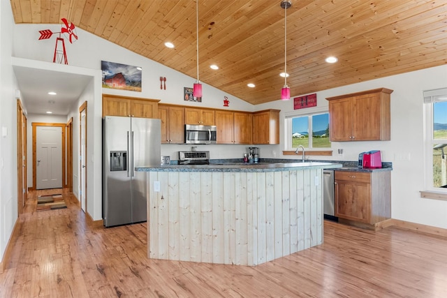 999 Websters Way, Stevensville, MT 59870 - kitchen with appliances with stainless steel finishes, dark countertops, light wood-style flooring, brown cabinets, and hanging light fixtures