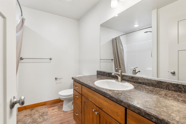 999 Websters Way, Stevensville, MT 59870 - full bath featuring wood finished floors, toilet, vanity, a shower with shower curtain, and baseboards