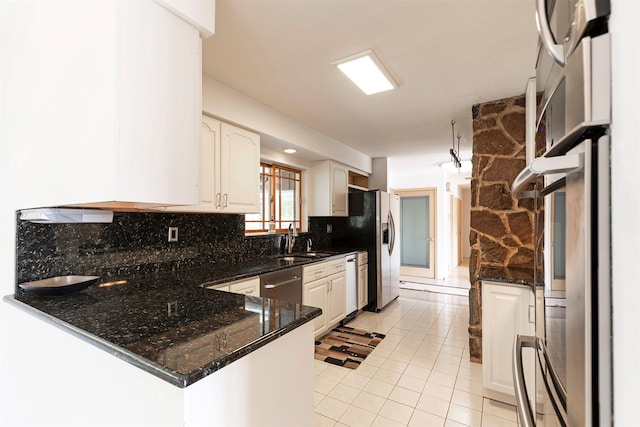 411 W River Rd, Hamilton, MT 59840 - kitchen with decorative backsplash, appliances with stainless steel finishes, dark stone countertops, a sink, and white cabinetry