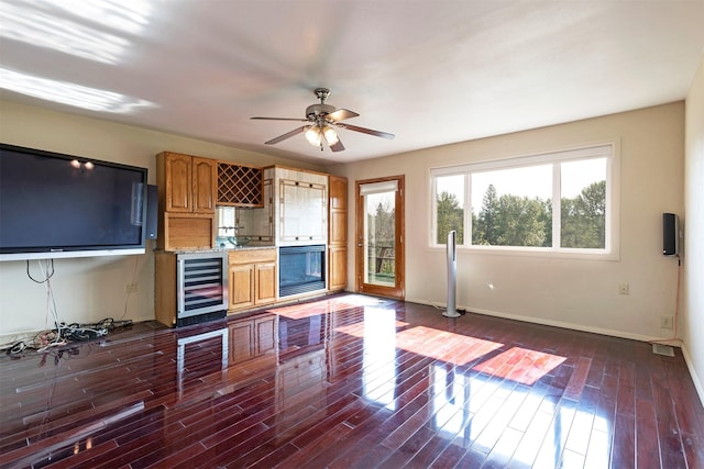 411 W River Rd, Hamilton, MT 59840 - unfurnished living room with wine cooler, baseboards, a ceiling fan, and dark wood-style floors