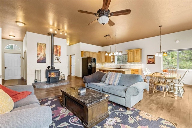 141 Aspen Ln, Eureka, MT 59917 - living room with light wood-type flooring, a wood stove, a ceiling fan, a textured ceiling, and lofted ceiling