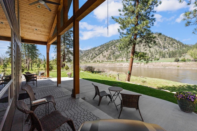 view of patio featuring a water and mountain view and ceiling fan