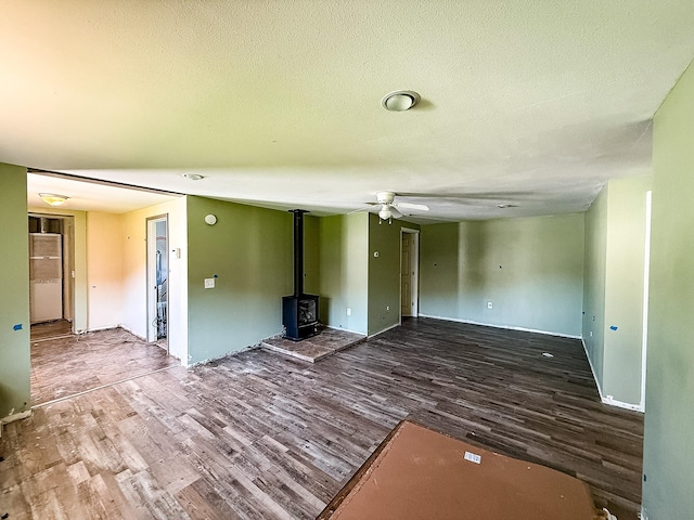 485 Wilson Butte Rd, Great Falls, MT 59405 - unfurnished living room with ceiling fan, wood finished floors, a wood stove, and a textured ceiling