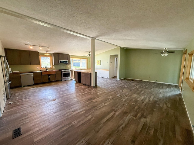 485 Wilson Butte Rd, Great Falls, MT 59405 - unfurnished living room featuring a ceiling fan, dark wood finished floors, a textured ceiling, baseboards, and vaulted ceiling