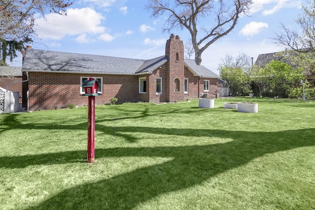3313 5th Ave N, Great Falls, MT 59401 - rear view of house featuring a chimney, brick siding, a lawn, and a shingled roof