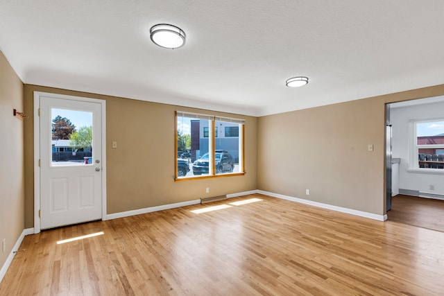 foyer featuring light wood-style floors and baseboards