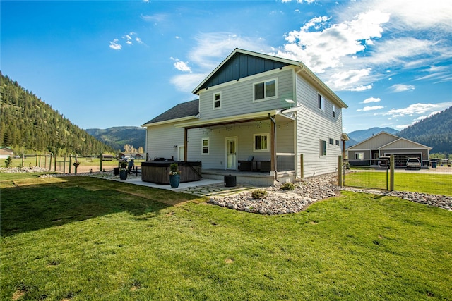 21087 Pamin Loop, Clinton, MT 59825 - back of house featuring a hot tub, a mountain view, a patio, and board and batten siding