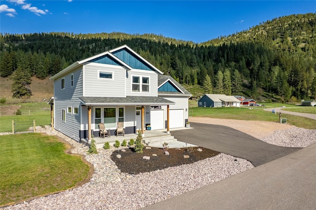 21087 Pamin Loop, Clinton, MT 59825 - view of front of property with a wooded view, covered porch, driveway, and a front yard