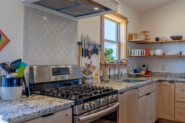 4175 Mchugh Ln, Helena, MT 59602 - kitchen with gas range, a sink, wall chimney range hood, and light stone counters