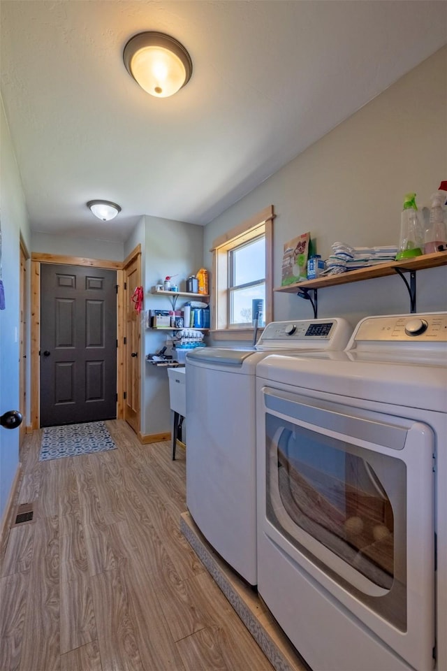 4175 Mchugh Ln, Helena, MT 59602 - clothes washing area with washing machine and dryer, light wood-style flooring, and baseboards